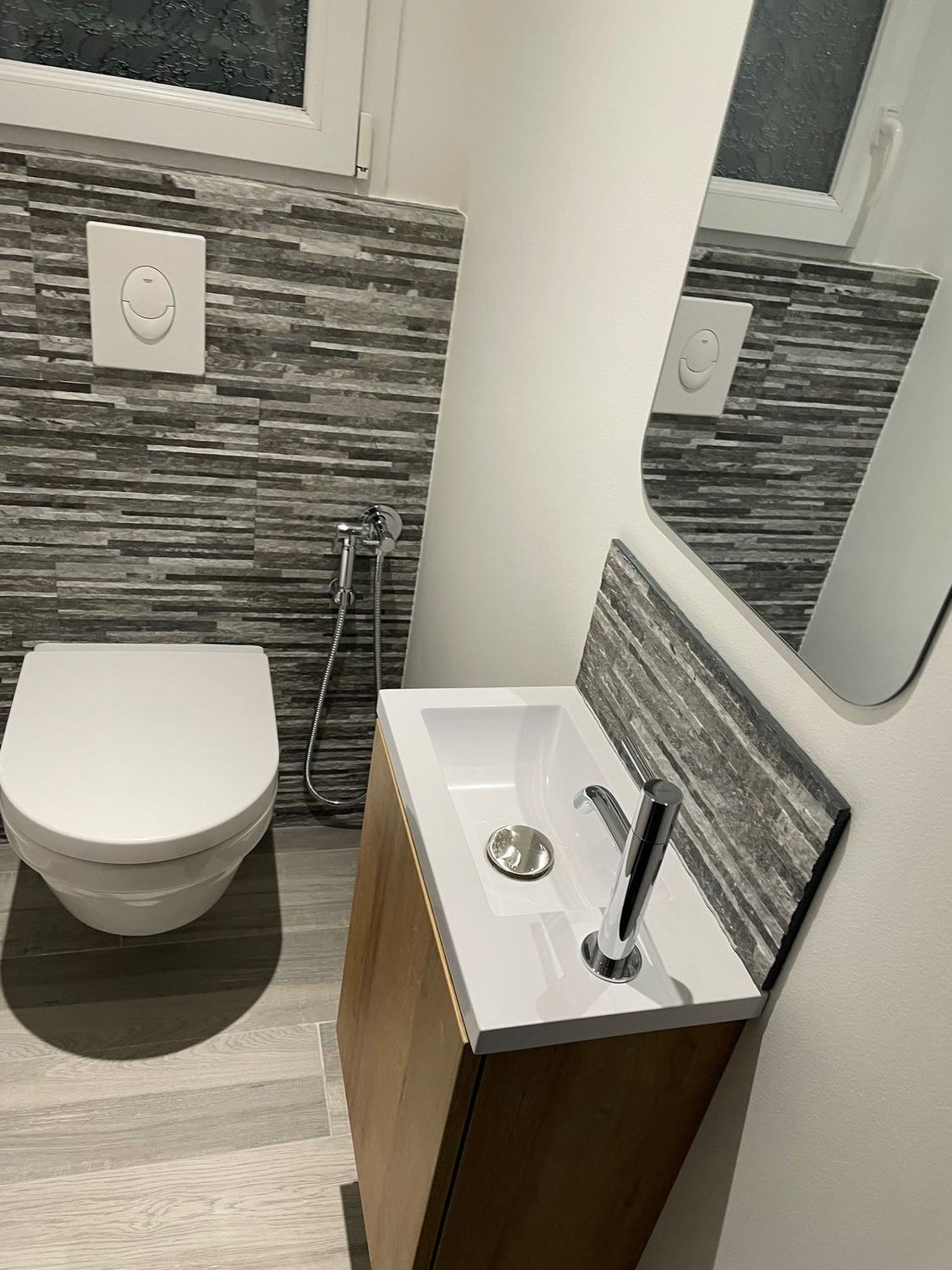 WC suspendu avec mur en pierre de parement et lave-mains