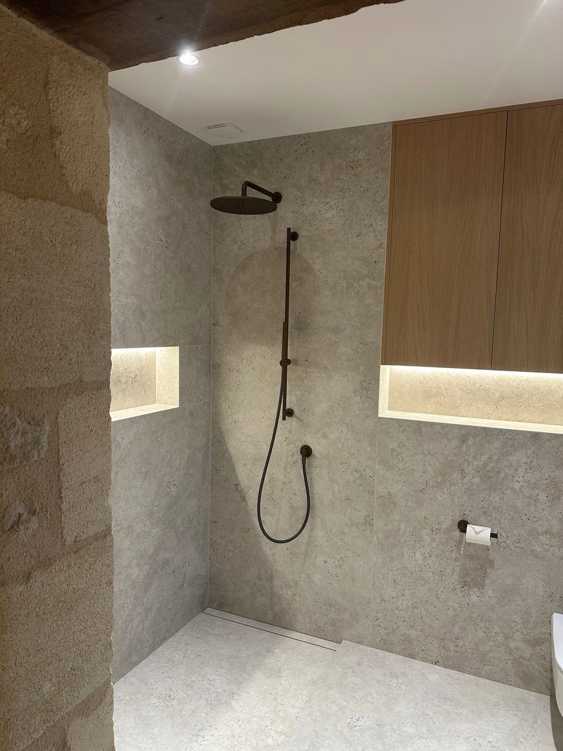Douche à l'italienne avec robinetterie noire et niches éclairées